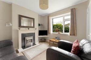 a living room with a couch and a fireplace at Rydal View Cottage in Ambleside