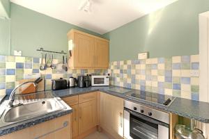 a kitchen with a sink and a stove at Rydal View Cottage in Ambleside