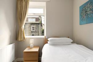 a small bedroom with a bed and a window at Rydal View Cottage in Ambleside