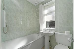 a bathroom with a sink and a toilet and a bath tub at Rydal View Cottage in Ambleside +8 photos