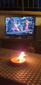 阿格罗波利B&B Stella del Cilento & Sole Rooms的电视机前的桌子上的蜡烛