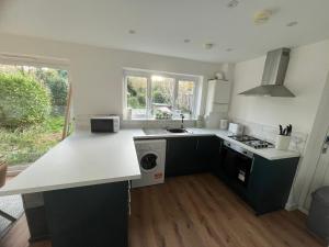 Woodfield Cottage Crawley 3 BR,Parking,Wifi,Garden, nearby Gatwick Airport, Contractor friendly, temporary relocations, business travellers, families في كراولي: مطبخ مع كونتر أبيض قمة وموقد +12 صورة