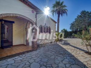 a villa with a church and a palm tree at Villa Paradise in Calonge
