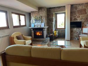 ein Wohnzimmer mit Couch und Kamin in der Unterkunft Casa da Lage - Lareira - Lenha - Vistas rio - Gerês in Geres