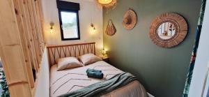 a small bedroom with a bed and a mirror at Villa Cosy - Proche Bordeaux in Parempuyre