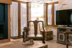 a living room with a chair and a flat screen tv at Villa Castello in Koiliomenos +48 photos