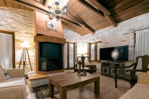 a living room with a fireplace and a tv at Villa Castello in Koiliomenos