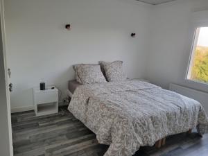 Una habitación blanca con una cama y una ventana en Belle maison proche de la mer, en Wimille