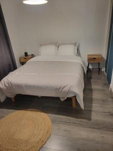 Una cama con sábanas blancas y almohadas en un dormitorio. en Belle maison proche de la mer, en Wimille