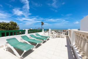 een rij ligstoelen op een terras met uitzicht op de oceaan bij Apartamentos LIVVO Erika in Corralejo