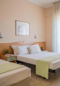 ein Hotelzimmer mit zwei Betten und einem Fenster in der Unterkunft Milano Simple in Bellaria-Igea Marina