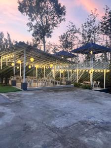 a large pavilion with tables and umbrellas at dusk at Aetheria Estate Retreat in Chikmagalūr