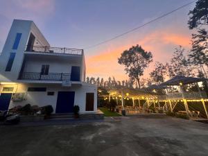 a white building with a sunset in the background at Aetheria Estate Retreat in Chikmagalūr