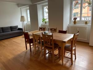 una sala da pranzo con tavolo e sedie in legno di Spacious light-flooded apartment with garden at Lake Zurich a Männedorf
