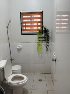 um banheiro branco com um vaso sanitário e uma janela em Kamayo Guest House -near Dahican beach em Dahikan mais 17 fotografias