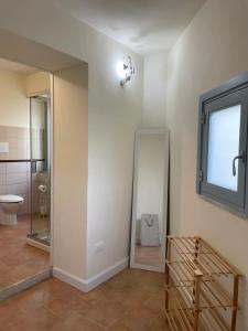 Un baño con inodoro, ventana y espejo. en A casa di Samuele, en Squille