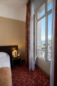 a bedroom with a bed and a window with a view at Excelsior in Saint-Raphaël +31 photos