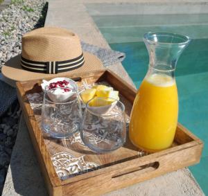 a tray with glasses and a bottle of orange juice at Sunsets and Olive Trees in Messini