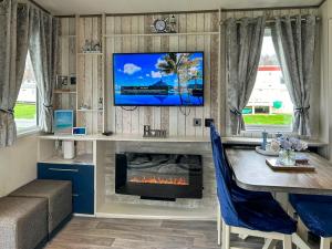 un soggiorno con camino e TV di Ocean Bay View - Ukc7143 ad Ayr