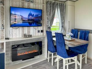 una sala da pranzo con una TV sopra un camino di Ocean Bay View - Ukc7143 ad Ayr
