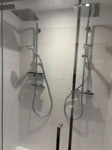 een badkamer met een douche met een douchekop bij Cosy Arc 1950, Ski-in Ski-out with Interior Swimming Pool, Sauna & Hammam in Arc 1950