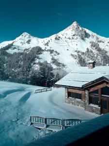 een hut met een met sneeuw bedekte berg op de achtergrond bij Cosy Arc 1950, Ski-in Ski-out with Interior Swimming Pool, Sauna & Hammam in Arc 1950 +34 foto's