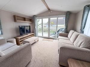 ein Wohnzimmer mit zwei Sofas und einem Fernseher in der Unterkunft Spacious 8 Berth Caravan With Decking At Naze Marine In Essex Ref 17012Rd in Walton-on-the-Naze