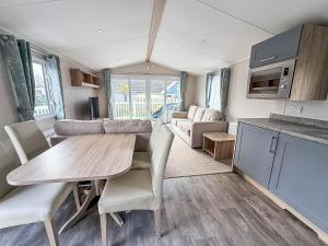 eine Küche und ein Wohnzimmer mit Tisch und Stühlen in der Unterkunft Spacious 8 Berth Caravan With Decking At Naze Marine In Essex Ref 17012Rd in Walton-on-the-Naze