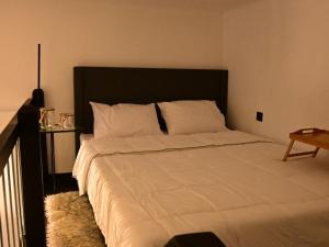 a bedroom with a large bed with a black headboard at NEKTAR home in Latsídha