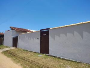 a white wall with a door on the side of it at Solares Aconchego - Suíte in Búzios