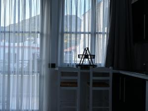 two white chairs sitting in front of a window at NEKTAR home in Latsídha