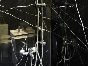 a black bathroom with a shower and a sink at NEKTAR home in Latsídha +38 photos
