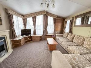 Una sala de estar con un sofá y un televisor en Homely 8 Berth Caravan Near To The Beach In Walton-On-The-Naze Ref 17157P, en Walton-on-the-Naze