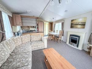 una sala de estar con un sofá y una mesa en Homely 8 Berth Caravan Near To The Beach In Walton-On-The-Naze Ref 17157P, en Walton-on-the-Naze