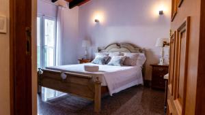 a bedroom with a bed with white sheets and a window at Villa Sa Muntanyeta con Piscina Infinity Privada in Manacor +30 photos