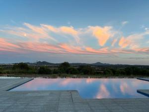 a large swimming pool with a cloudy sky above it at Villa Sa Muntanyeta con Piscina Infinity Privada in Manacor