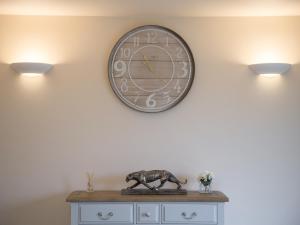 a clock on a wall with a statue on a dresser at Field View - Ukc2304 in Wainfleet All Saints