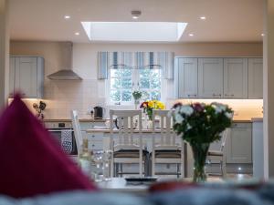 a kitchen with a table with chairs and flowers on it at Field View - Ukc2304 in Wainfleet All Saints
