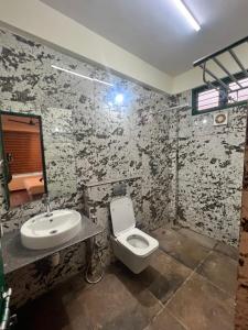 a bathroom with a toilet and a sink at Aetheria Estate Retreat in Chikmagalūr