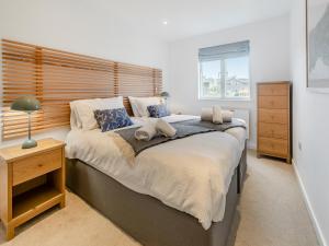 a bedroom with a large bed with a wooden headboard at Lodge 52 Una in Carbis Bay +34 photos