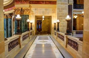 Un pasillo en un edificio con columnas y pinturas en las paredes. en Spain apart, en Algorta