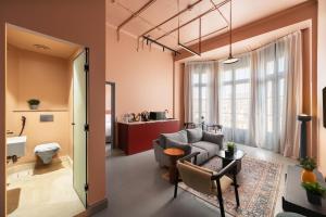 uma sala de estar com um sofá e uma cadeira em grey l studio apartments Downtown Cairo Bidair House em Cairo