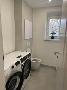 una lavadora en un baño con inodoro en Apartmán Sihoť - pri Zimnom Štadióne, en Trenčín 18 fotos más