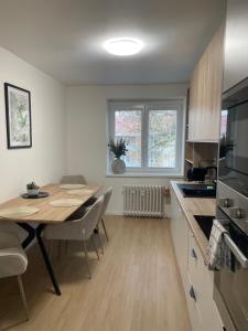 Una cocina con una mesa de madera y un comedor. en Apartmán Sihoť - pri Zimnom Štadióne, en Trenčín