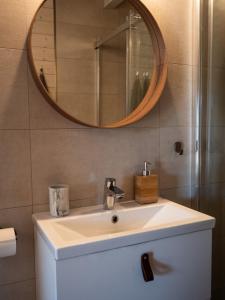 a bathroom with a sink and a mirror at APANÓWKA domki z balią jacuzzi sauna in Trzebiechowo +19 photos