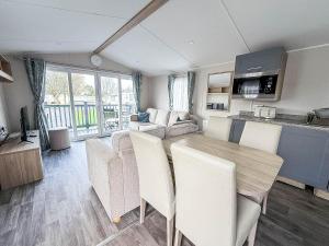 内兹岬附近沃尔顿Modern 8 Berth Caravan With Decking At Naze Marine Park, Essex Ref 17145P的配有桌椅的厨房和客厅