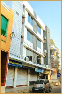 a car parked in front of a building at Mahakal Road The Shikhar #Avenue Residency Near Ujjain Junction Railway Station 500m-Mahakaleshwar Jyotirlinga - Free Wifi and Lift Facilities # Air Conditioning Rooms - Best Premium Hotel In Ujjain in Ujjain