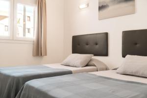 two beds sitting next to each other in a room at Apartamento Puerto del Carmen Las Vistas 247 in Tías