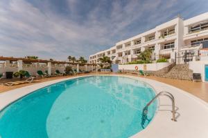 a large swimming pool in front of a hotel at Apartamento Puerto del Carmen Las Vistas 247 in Tías