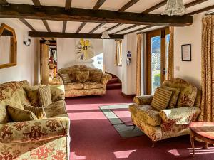 a living room with couches and a table at Duvale Barn in Bampton +54 photos